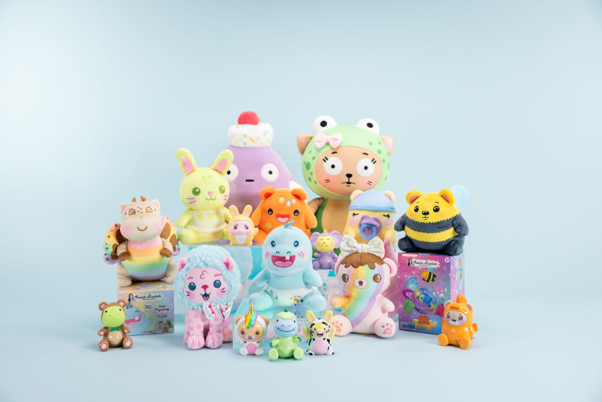 Colorful plush toys, blind-box figures and mystery boxes arranged on a light blue backdrop